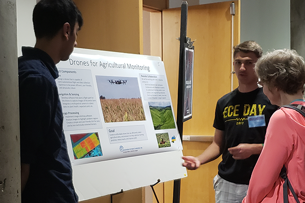 Student talking beside research poster