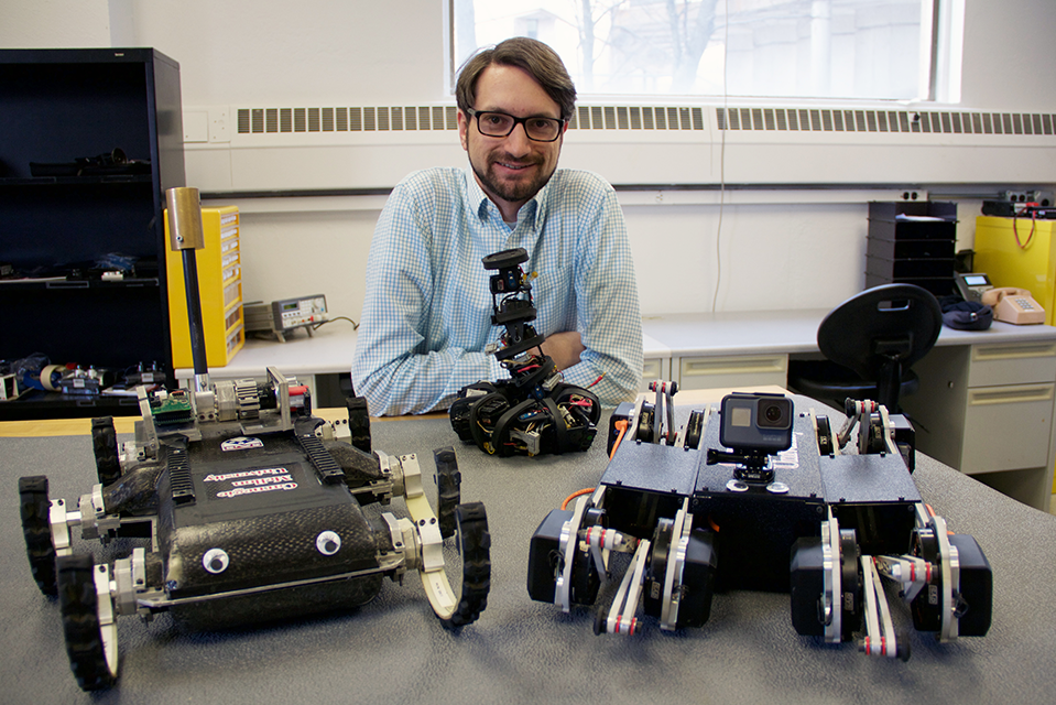 Aaron Johnson in his lab with some of his robots.
