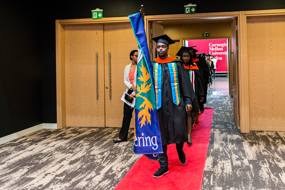 Photo of a CMU Africa student carrying the CMU Engineering flag